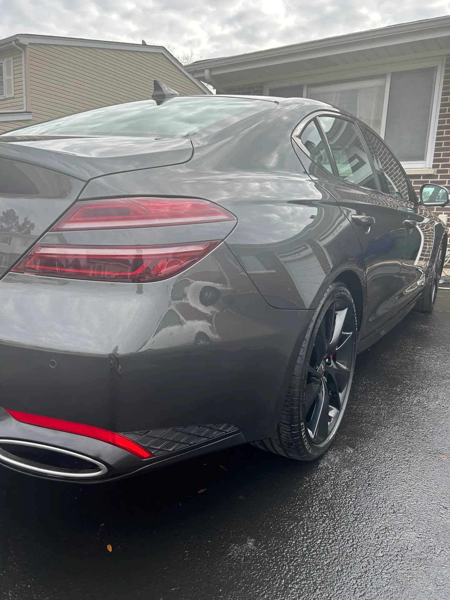 Gray sedan with glossy paint after a full detail on a wet driveway